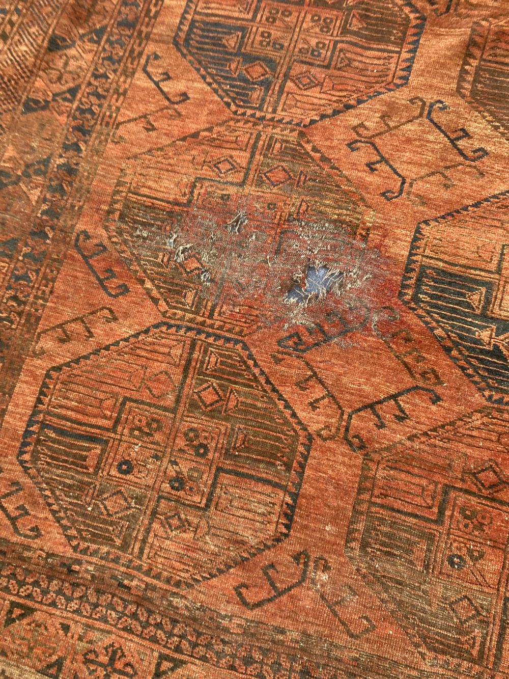 An antique Bokhara burgundy ground carpet, 400 x 280cm
